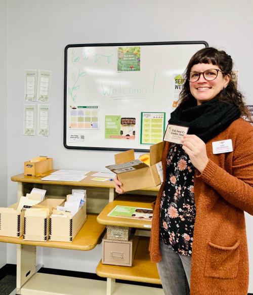 Electronic Resources Librarian Julia Haverstock stands next to the seed library at Blue Ridge Community College 