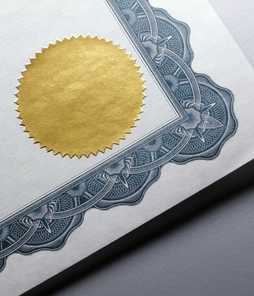 A gold seal on a certificate resting on a gray background. 