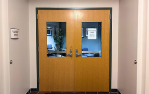 wooden double doors with posted Environmental Health office hours