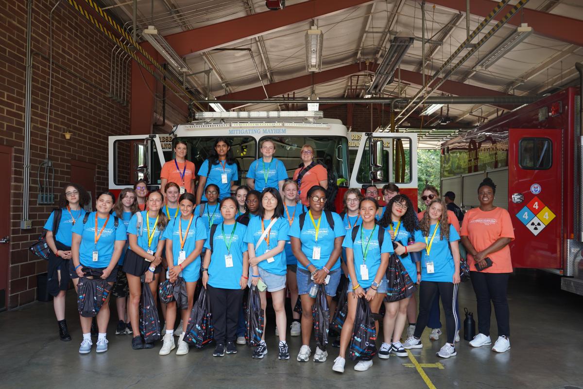EM Experience young ladies standing in front of a fire truck